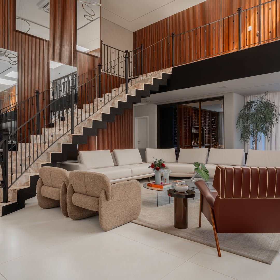Sala de estar de alto padrão com escada e painéis de madeira